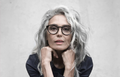 Lady-with-long-grey-hair-wearing-round-black-gvvlasses.webp